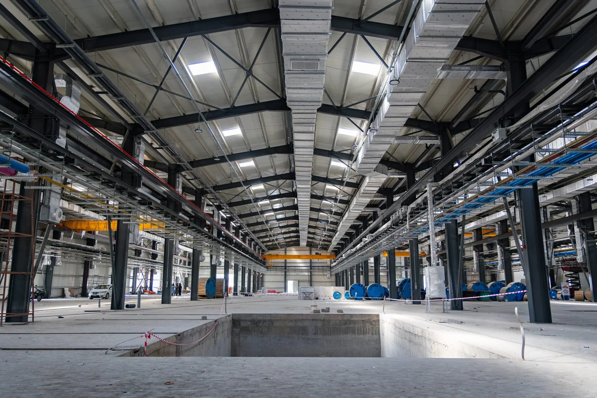 Completed industrial hall with coordinated steel structure, ventilation ducts and overhead services